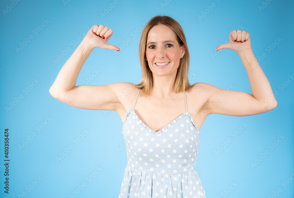 Smiling pretty young woman showing thumbs up isolated over blue background Smiling pretty young woman showing thumbs up isolated over blue background