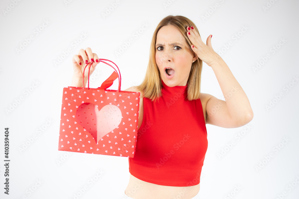 Young surprised woman holding a red bag over white background. Young surprised woman holding a red bag over white background.