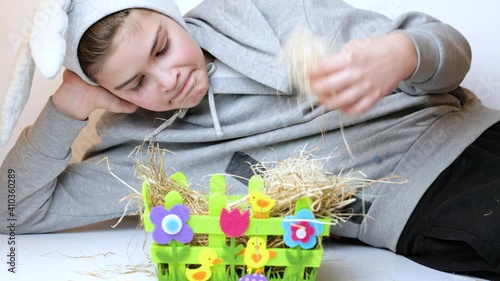 Cute boy in bunny ears having fun and in basket hunt for easter eggs . Traditional easter game search Easter egg