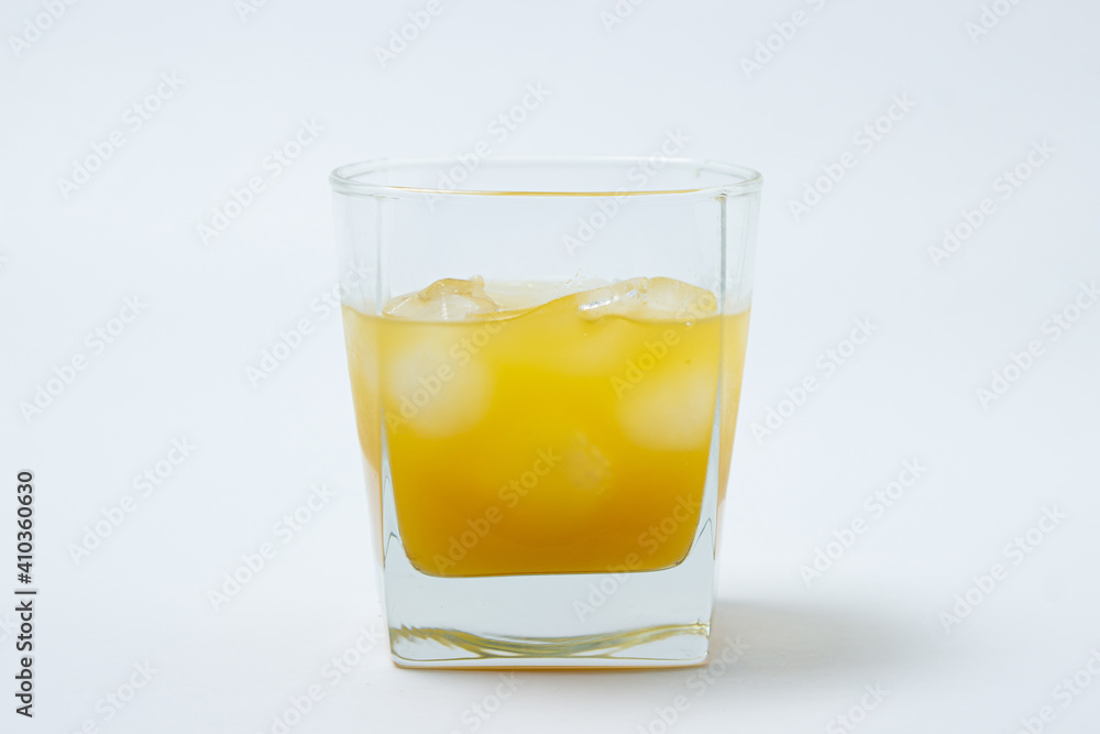 Juice with ice in a glass on a white background. Natural mango juice. Refreshing drink