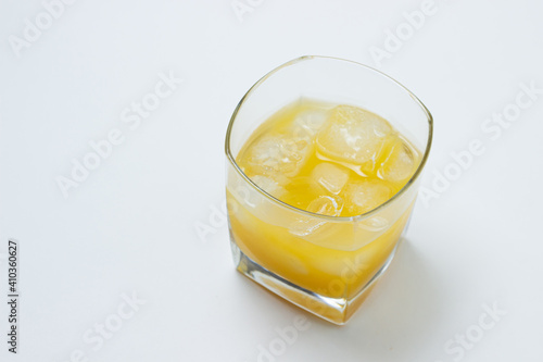 Juice with ice in a glass on a white background. Natural mango juice. Refreshing drink