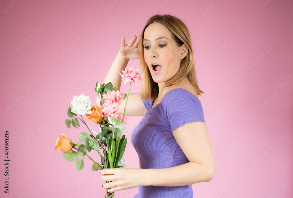 Portrait of a beautiful young woman holding big bouquet of flowers isolated over pink background. Portrait of a beautiful young woman holding big bouquet of flowers isolated over pink background.