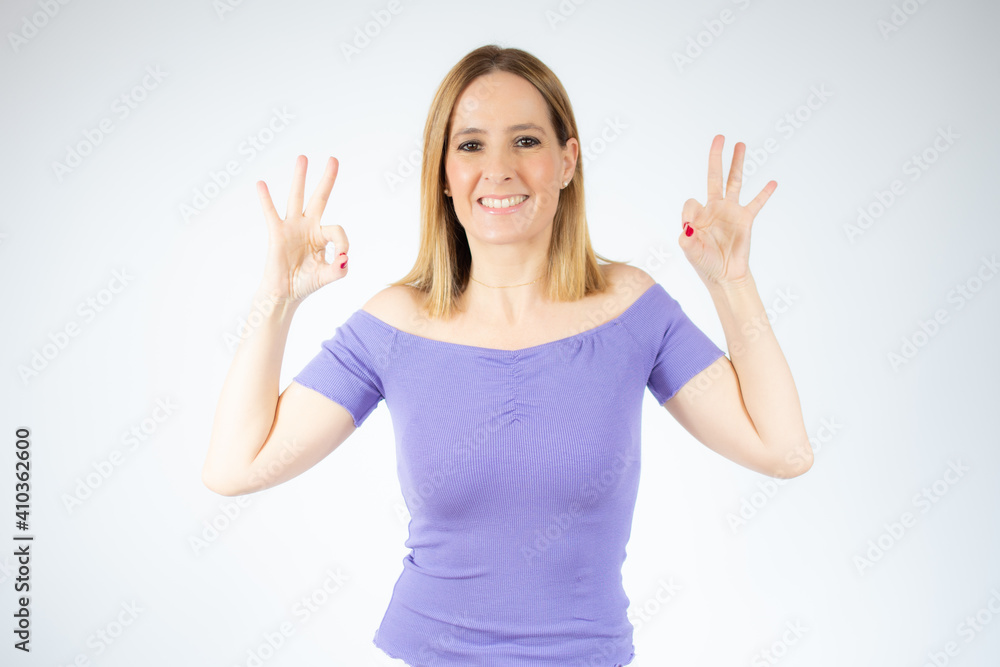 Beautiful woman standing over isolated background doing okay sign with fingers, excellent symbol. Beautiful woman standing over isolated background doing okay sign with fingers, excellent symbol.