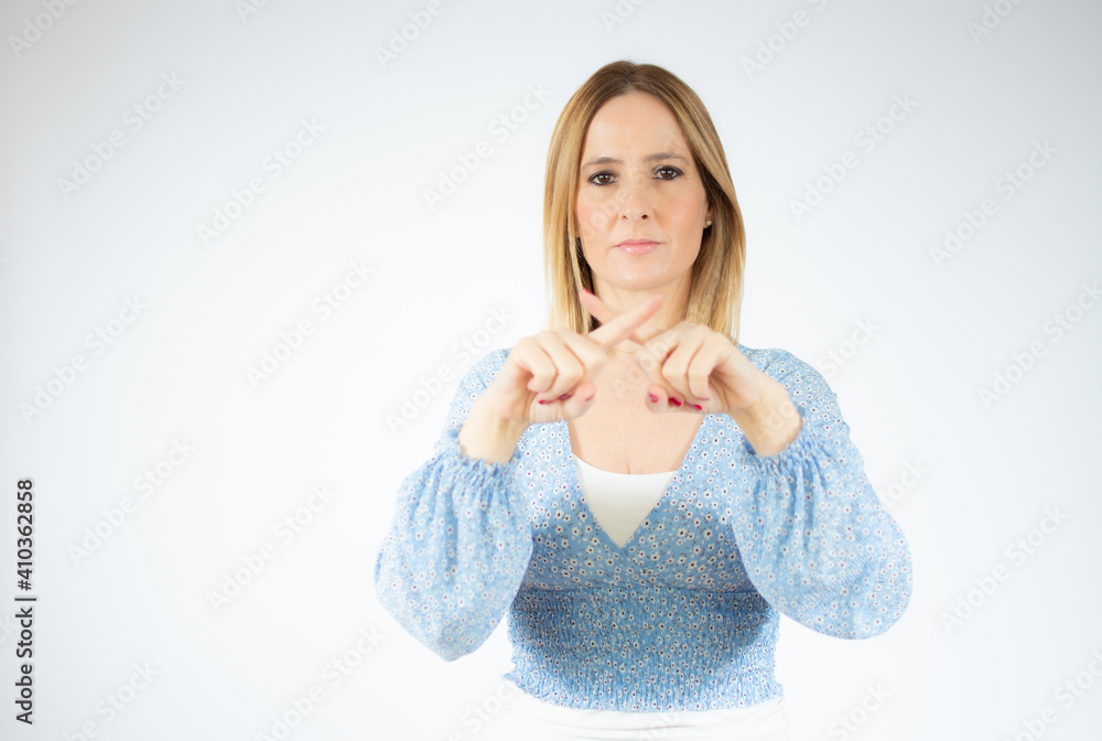 Young woman wearing blue shirt standing over white isolated background rejection expression crossing fingers doing negative sign Young woman wearing blue shirt standing over white isolated background rejection expression crossing fingers doing negative sign