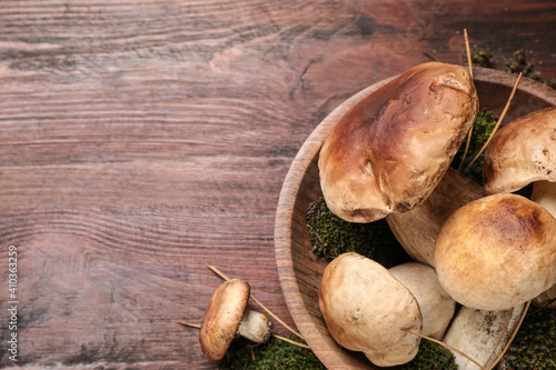 Fresh wild porcini mushrooms on wooden table, top view. Space for text