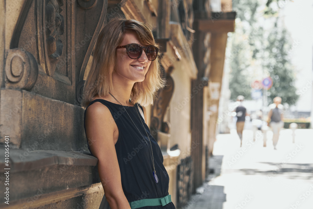 Obraz premium Woman posing on the street sidewalk.