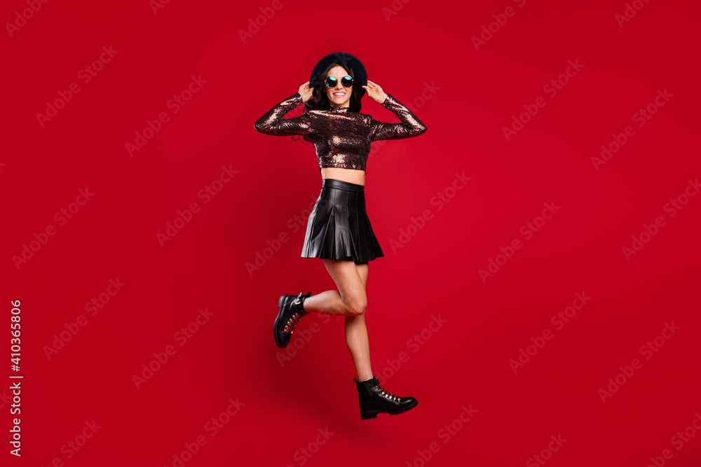 Full body profile side photo of happy nice girl jump up air wear boots isolated on red color background Full body profile side photo of happy nice girl jump up air wear boots isolated on red color background