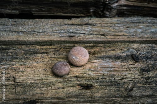 Two round rocks on wood board. How nature creates uncannily spherical boulders. Round rocks. photo