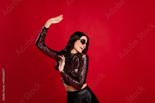 Photo of dreamy funky stunning young woman dance good mood wear sunglass isolated on red color background © deagreez