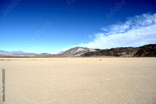 moving stones on the Racetrack Playa leaving tracks in the dry and cracked terrain in the Death Valley National Park, recflections of the sun