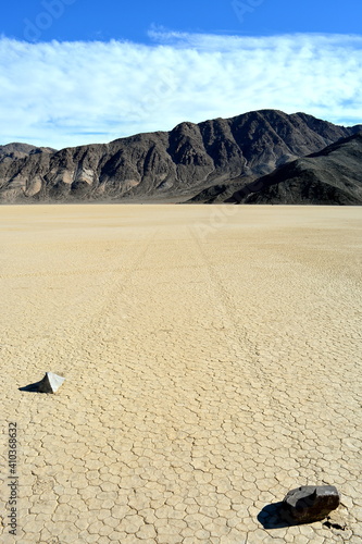 moving stones on the Racetrack Playa leaving tracks in the dry and cracked terrain in the Death Valley National Park, recflections of the sun photo