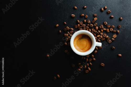 Steaming espresso served in cup on dark