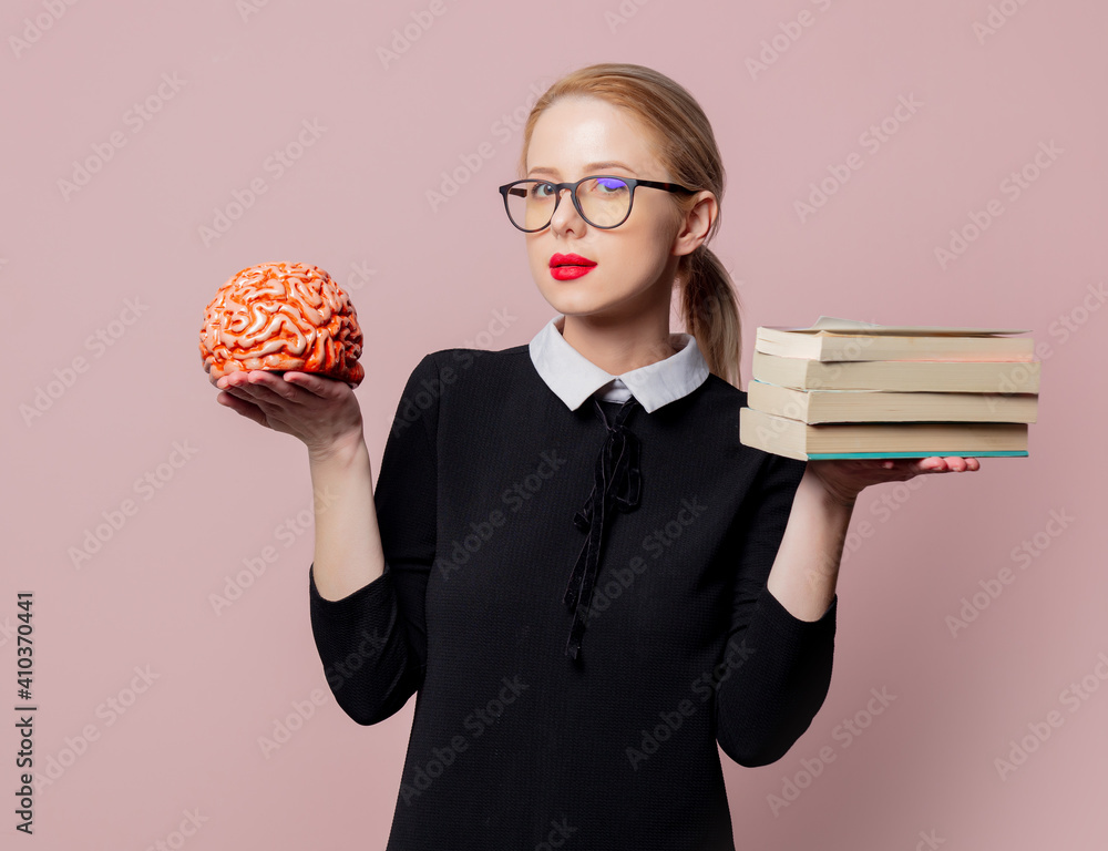 Φωτογραφία Blonde woman in black dress with books and brain on pink background