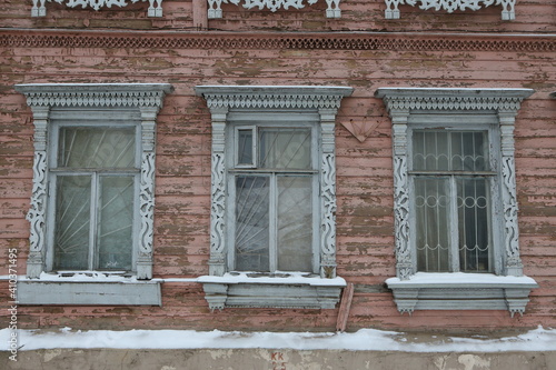 Ornamental windows with carved frames on vintage wooden house on Shagova street, 28, Kostroma city, Russia. Building facade. Russian traditional national folk style in architecture. Russian landmark photo