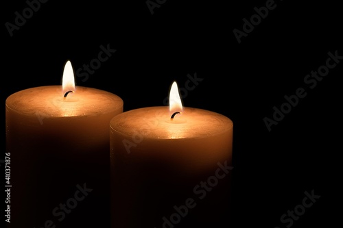 Two candles burning in the dark