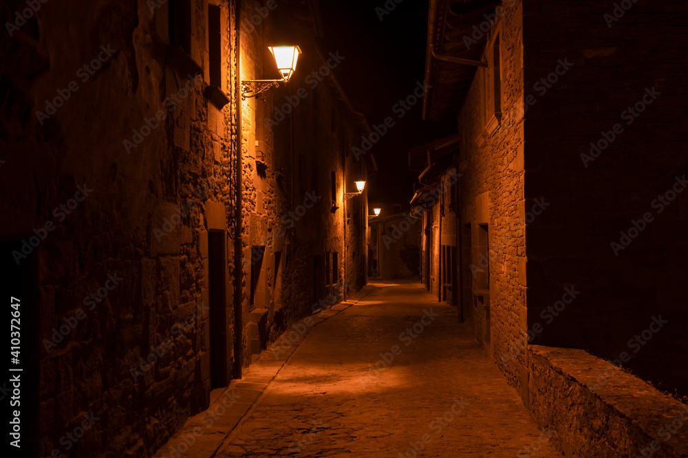 Amazing night view of old stone street with lamps lighting in ancient medieval village of Rupit , Barcelona , Spain.Traveling in Europe concept , urban countryside background.