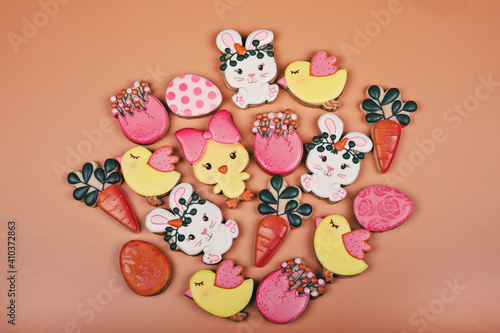 Fototapeta Naklejka Na Ścianę i Meble -  Closeup of variation of different Easter sugar cookies decorated with royal icing. Eggs, bunny, carrots and chicken on yellow background. Lovely sweet gift or postcard