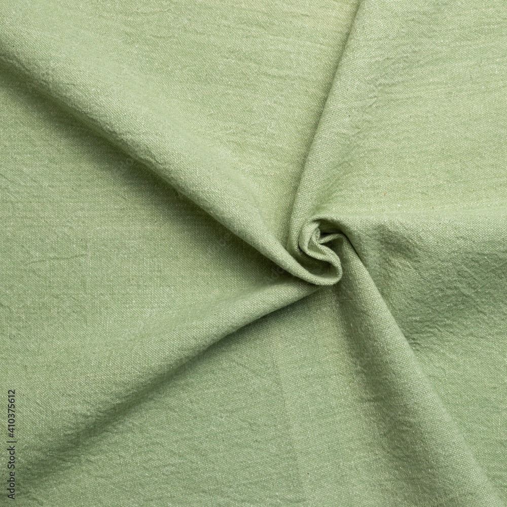 Crumpled natural green fabric texture background