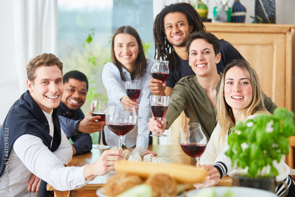 Happy friends celebrating with a glass of red wine at home Happy friends celebrating with a glass of red wine at home