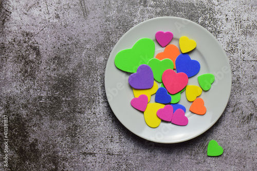 Valentine, love, special day. Multi-colored hearts on a white plate. Stone background and copy space.