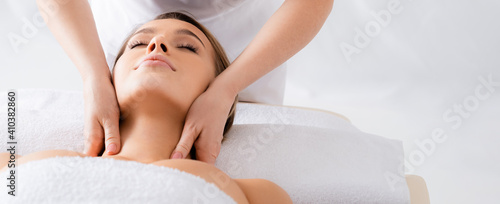 Schilderij op canvas Masseur doing neck massage to client with closed eyes in spa salon, banner