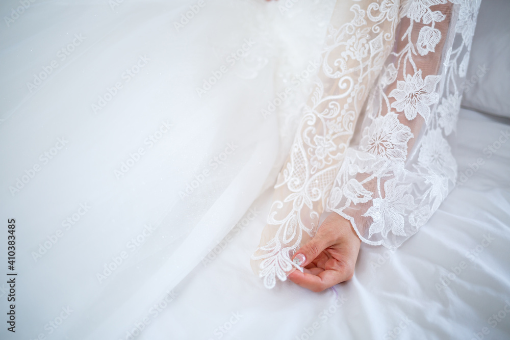 The bride holds a white dress in her hands on the wedding day. The bride holds a white dress in her hands on the wedding day.
