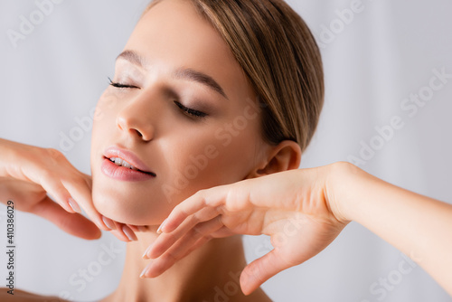 Murais de parede sensual young woman with closed eyes touching face on white