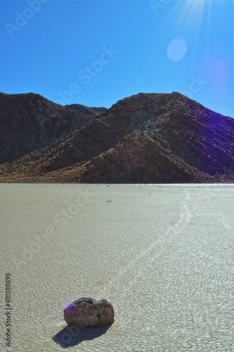 moving stones on the Racetrack Playa leaving tracks in the dry and cracked terrain in the Death Valley National Park, recflections of the sun photo