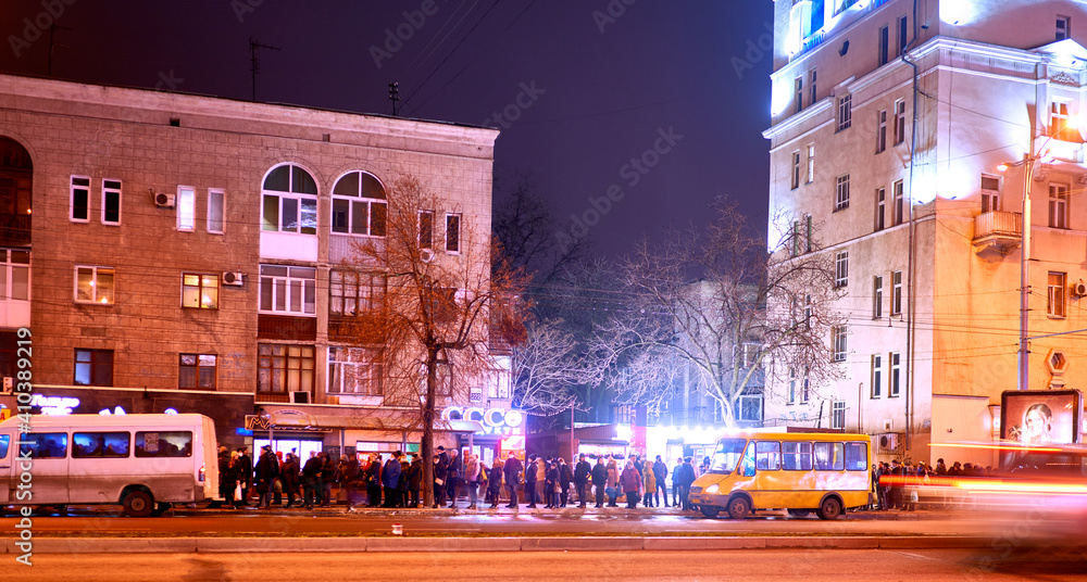 Obraz premium people at a bus stop in a night European city