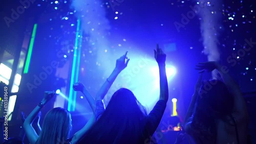 Group of fashionable woman friend celebrating and dancing in night club with illuminated neon night lights. Confidence female enjoy and having fun dance party and nightlife together at disco nightclub photo