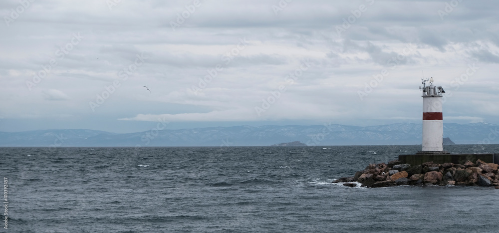 Panorama of the lighthouse on a cloudy day in Istanbul, Turkey. One of the lighthouses on the breakwaters. Advertising banner or poster with copy space. Flying seagulls. Bosphorus and Sea of Marmara. Panorama of the lighthouse on a cloudy day in Istanbul, Turkey. One of the lighthouses on the breakwaters. Advertising banner or poster with copy space. Flying seagulls. Bosphorus and Sea of Marmara.