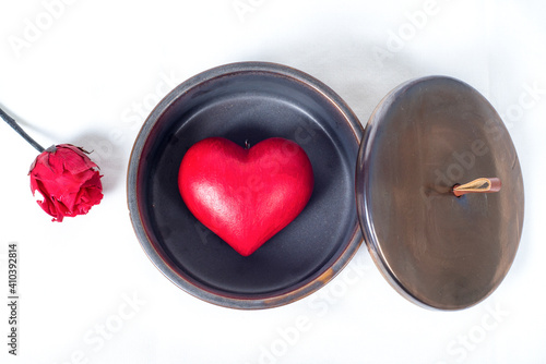 Top view on a red love heart inside a round gift box and a red rose, and a white background. Gift concept for valentine's day, and love  