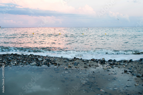 Εκτύπωση καμβά A beautiful cloudy sunset over the beach with a pebbly foreshore with a puddle after a rain