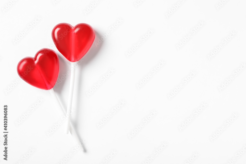 Sweet heart shaped lollipops on white background, flat lay with space for text. Valentine's day celebration