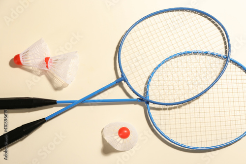 Badminton rackets and shuttlecocks on light background, flat lay