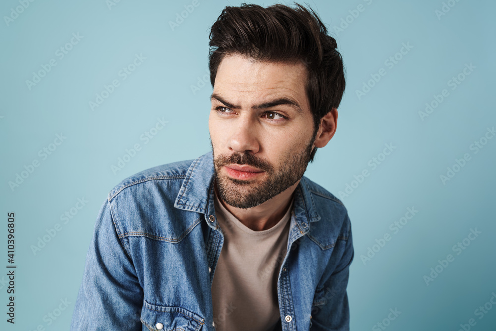 Fototapeta premium Young handsome brooding guy thinking and looking aside