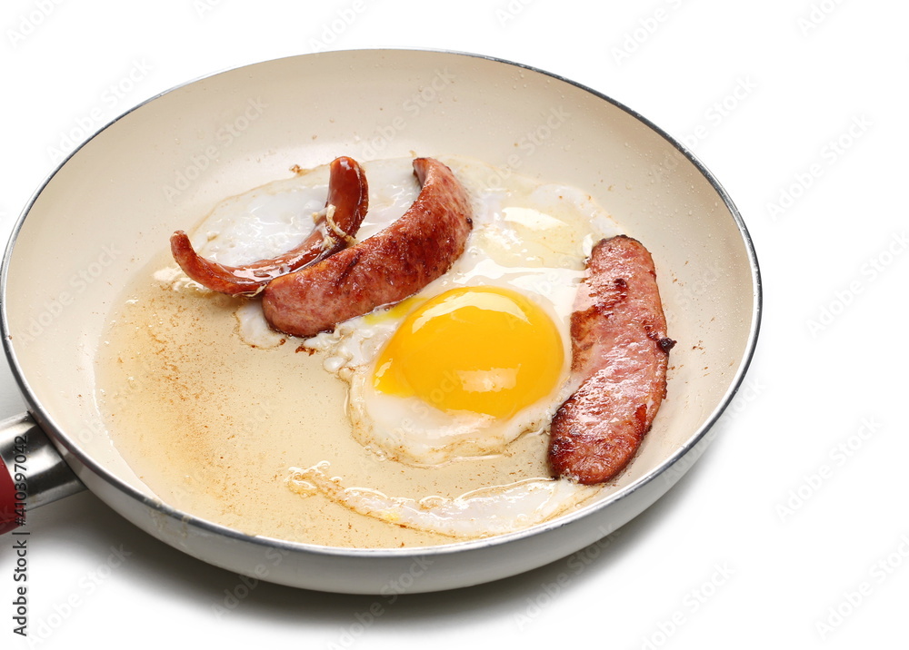 Fried sausages and sunny side up egg in frying pan isolated on white background Fried sausages and sunny side up egg in frying pan isolated on white background