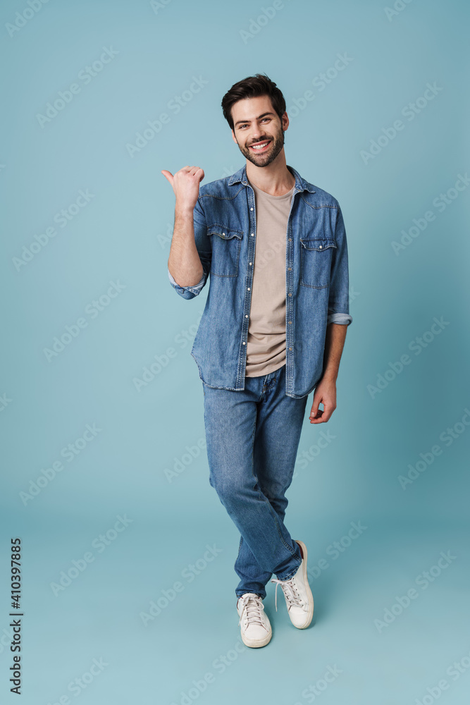 Young handsome guy pointing finger aside at copyspace Young handsome guy pointing finger aside at copyspace