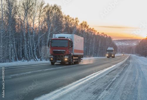 Trucks move in winter along country road