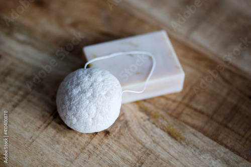 Natural cosmetics on wooden background. Flat lay top view skin care products branding mock up. Natural konjac sponge and natural hand made soap. Healthy lifestyle, zero waste cosmetic routine. 