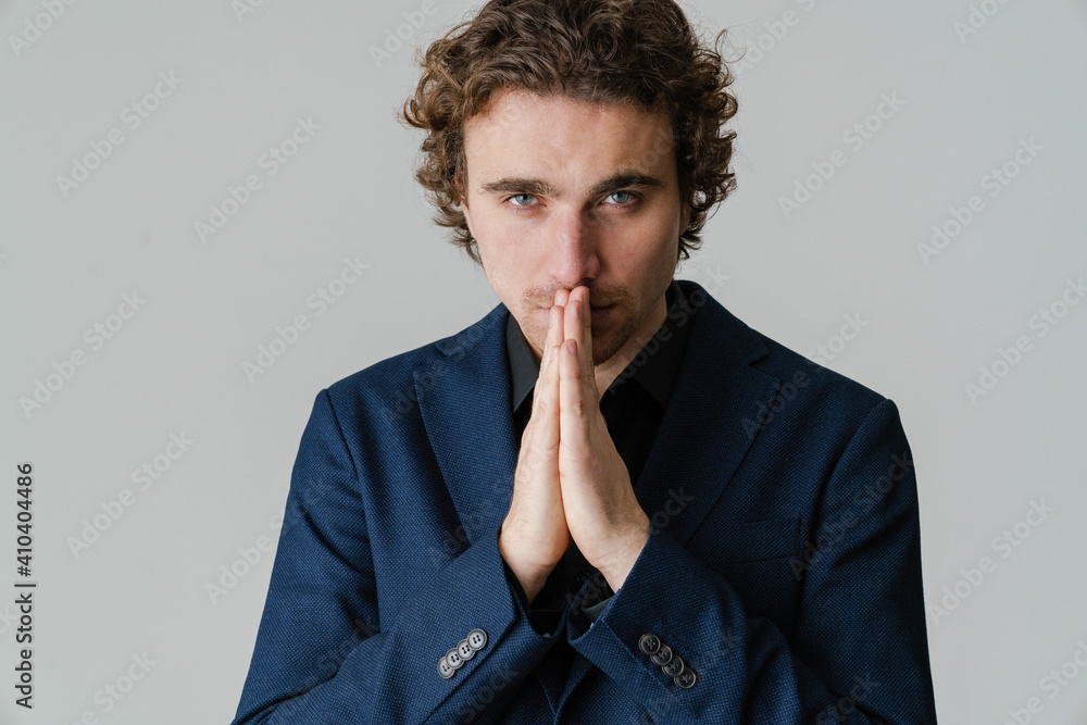 Confident handsome man in jacket holding palms together Confident handsome man in jacket holding palms together