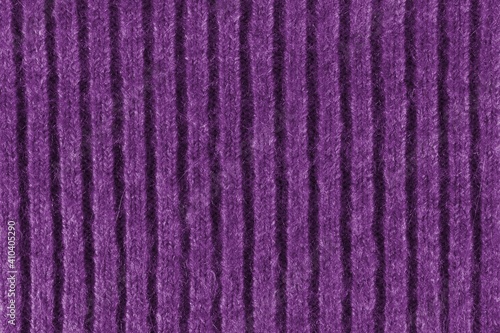 Purple texture of a knitted English elastic pattern. Horizontal background from a close-up of a knitted violet-colored canvas. Textile concept