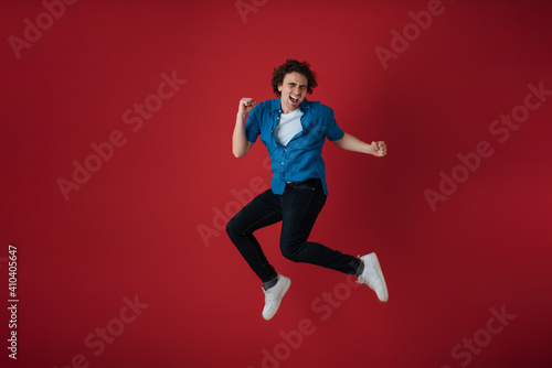 Excited handsome young man making fun while jumping