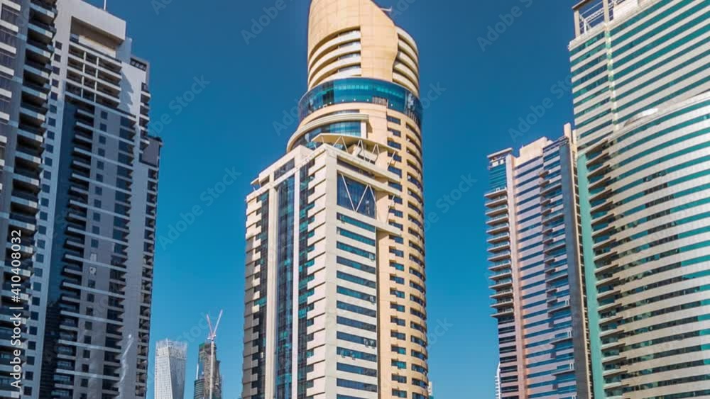 Timelapse hyperlapse view on skyscrapers at waterfront with palms. Residential buildings covered with glass in Jumeirah Lake Towers reflected in water in Dubai, UAE. View from embankment Timelapse hyperlapse view on skyscrapers at waterfront with palms. Residential buildings covered with glass in Jumeirah Lake Towers reflected in water in Dubai, UAE. View from embankment