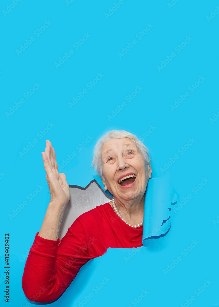Surprised woman looking through hole in paper wall. Surprised woman looking through hole in paper wall.