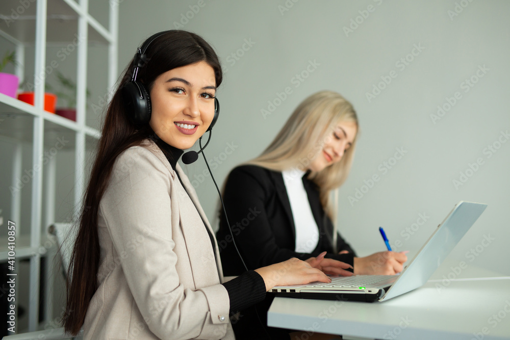 two beautiful young women in the office with a laptop two beautiful young women in the office with a laptop
