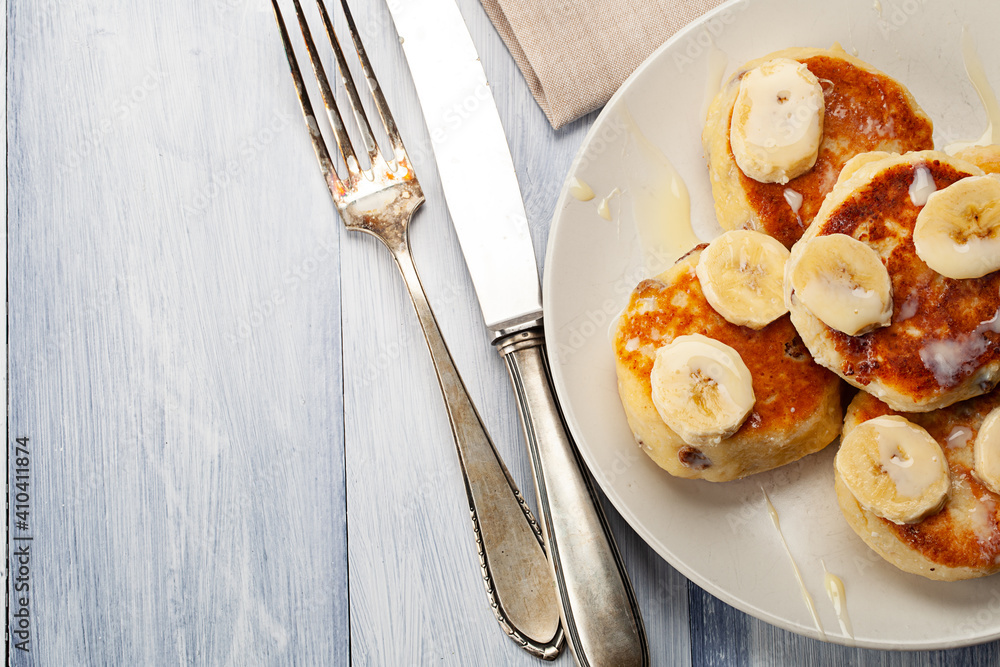 Homemade pancakes with raisins poured on with condensed milk and served with cutted bananas Homemade pancakes with raisins poured on with condensed milk and served with cutted bananas