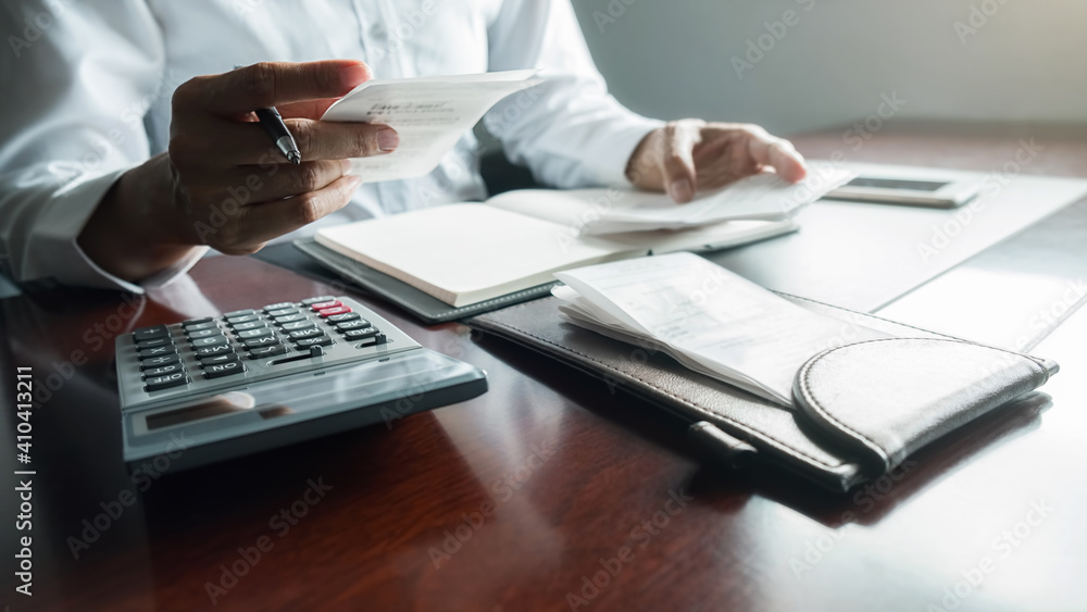 Woman with bills and calculator. Woman using calculator to calculate bills at the table in office. Calculation of costs. Woman with bills and calculator. Woman using calculator to calculate bills at the table in office. Calculation of costs.