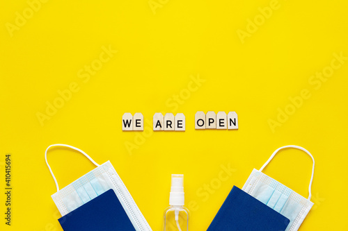 Accessories for travelers and text We are open on a yellow background. Coronavirus travel concept. Pandemic.