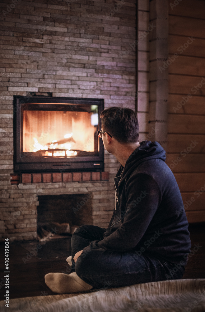 man sitting in front of fireplace man sitting in front of fireplace